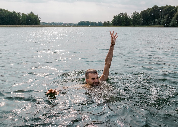 Young man drowning in a lake